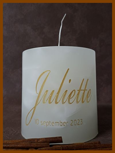 Een lage ronde doopkaars met één lontje. De naam Juliette en de doopdatum zijn in een sierlijk gouden lettertype met de hand op de kaars geschilderd.