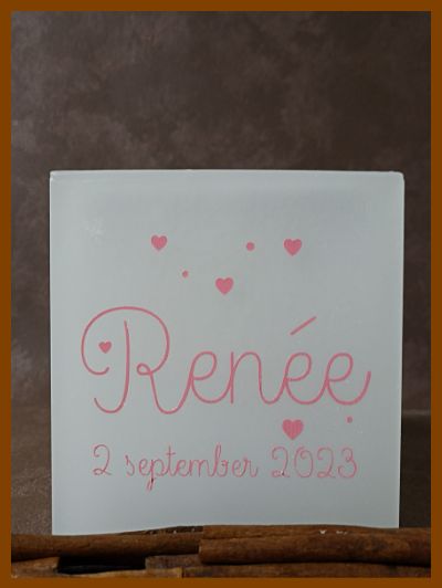 een waxinelichtje in een vierkant windlicht als doopkaars voor Renée met roze letters