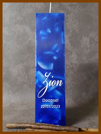 Een donkerblauwe doopkaars met witte naam Zion en doopseldatum.