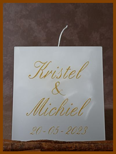Een online bestelde handgemaakte gepersonaliseerde huwelijkskaars met trouwringen en namen in een sierlijk lettertype.